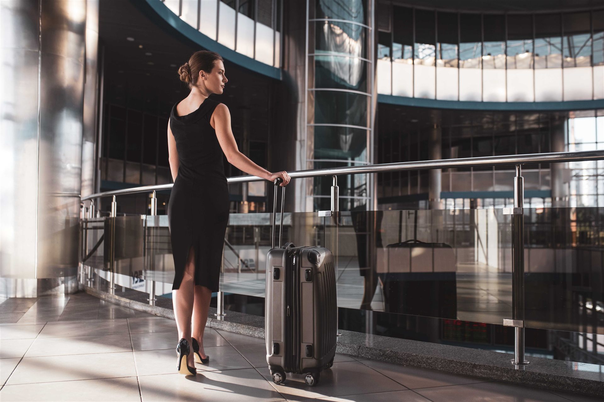 Mujer en la entrada de una terminal VIP privada de aeropuerto antes de embarcar en un vuelo chárter.